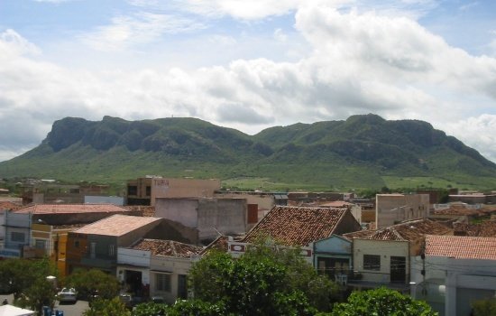 Vista de casas em primeiro plano com serra ao fundo