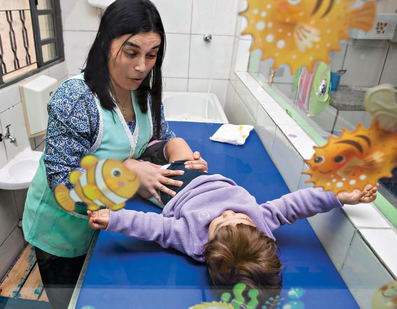 Professora do CEI Paulino Eva troca fralda de criança