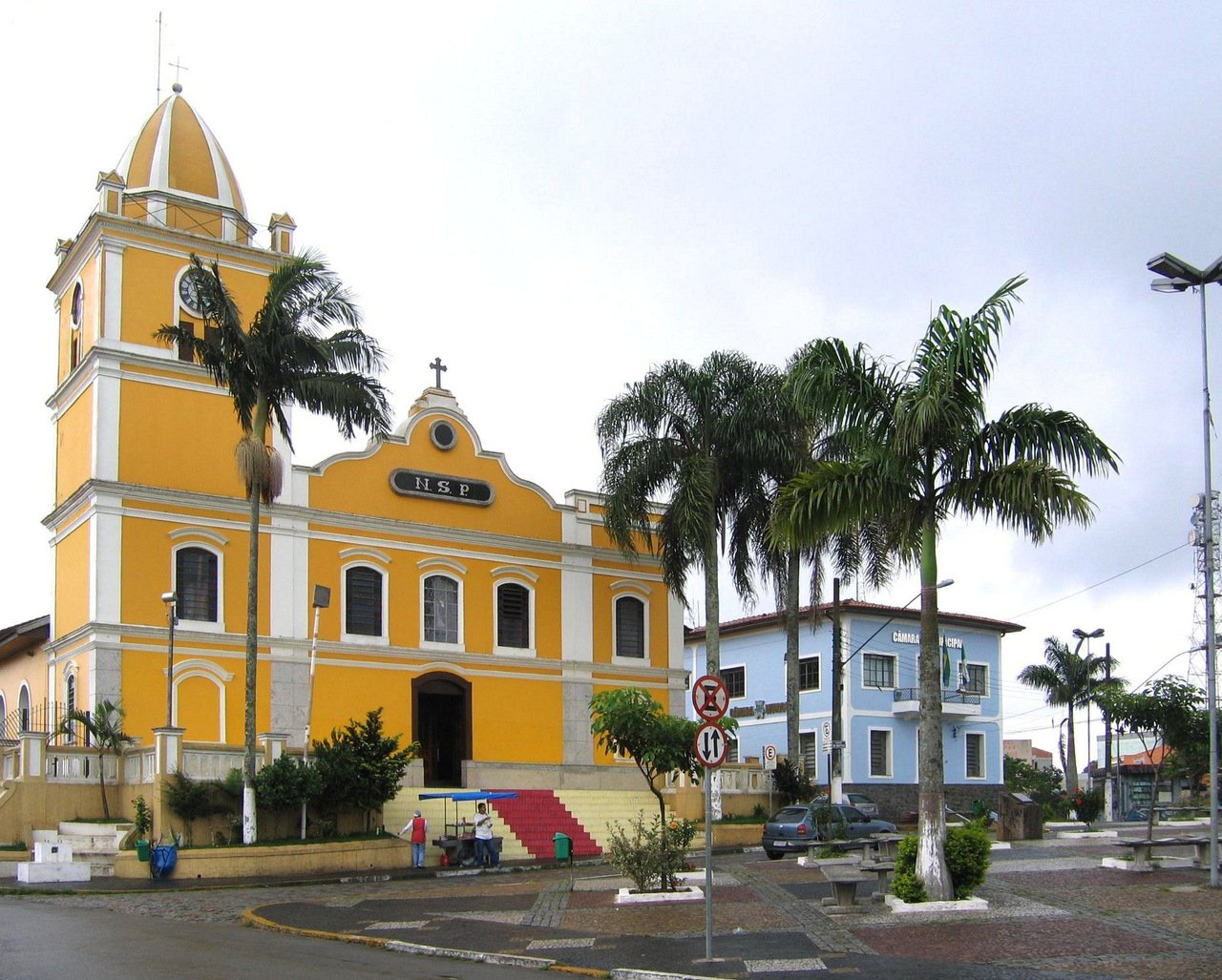 Igreja amarela com detalhes brancos e tapete vermelho na escadaria