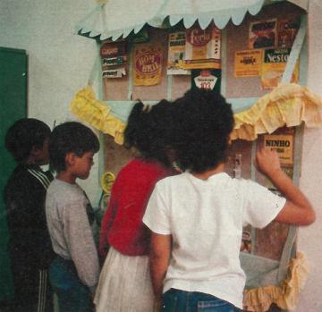 Crianças lendo rótulos em cartaz