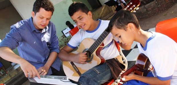 Orientação do professor À medida que os alunos iam estudando as músicas de Cartola no pátio da escola, Alessandro passava por todos, tocava junto, tirava dúvidas e orientava os estudantes na prática. Foto: Marco Monteiro