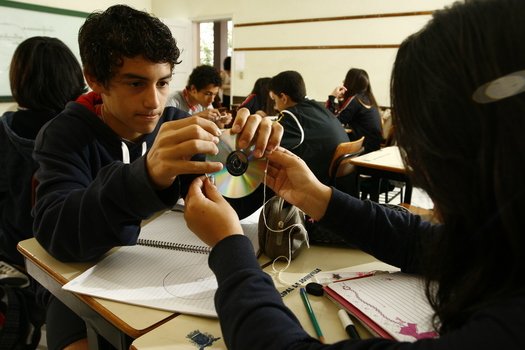 Medição de objetos e cálculo do pi Após discutir a diferença entre círculo e circunferência, a garotada usou a roda da bicicleta, CDs e colas bastão, para analisar a relação entre o comprimento (c) e o raio (r) da circunferência. Ao tirar as medidas e dividir comprimento pelo diâmetro (2r), os alunos chegaram ao número ? (pi).