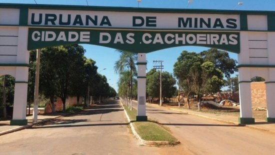 Portal da cidade de Uruana de Minas pintado em bege e verde escuro em que se lê "cidade de cachoeiras"