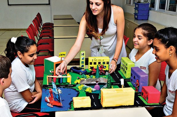 Maria Aline e um grupo de alunos observam uma das maquetes criadas no projeto. Marcio Salata