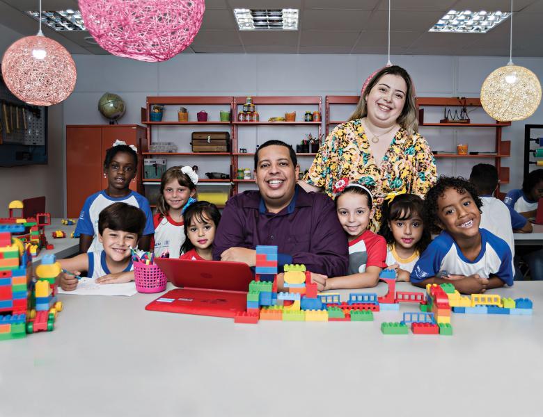 Reportagem sobre PPP com gestor e crianças em uma mesa com brinquedos