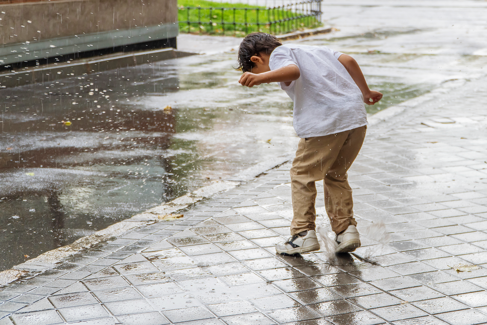 Aluno brincando e observando a chuva