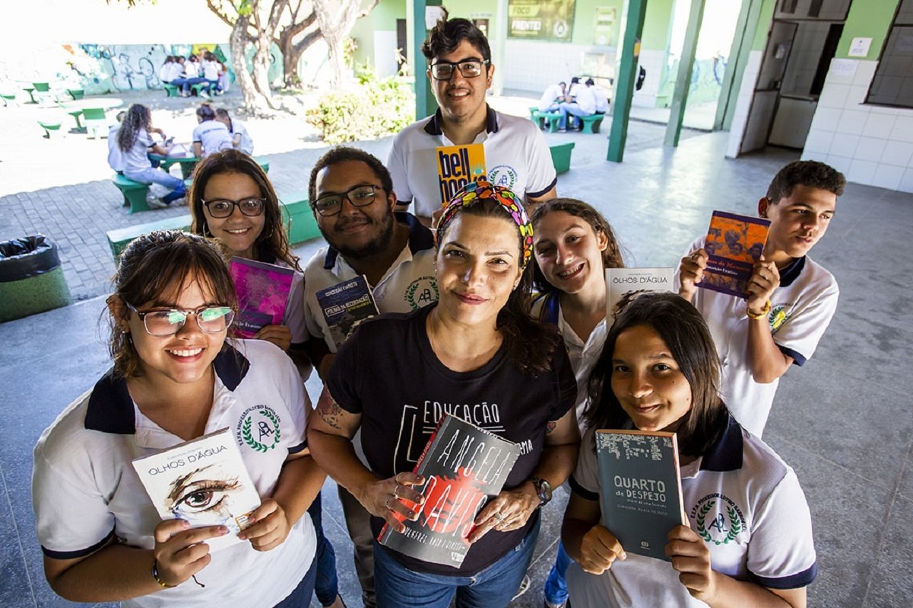 A professora Camile Baccin de Moura e os alunos da EEFM Aloysio Barros Leal mostram os livros pesquisados