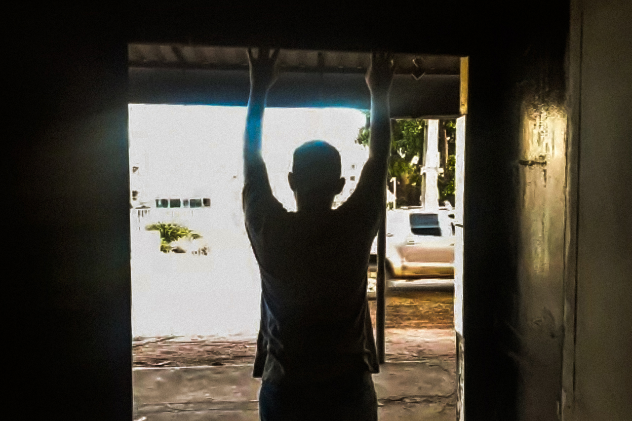 Fotografia feita remotamente via google duo do aluno Wallisson Marinho, estudante do 3º ano do ensino médio na rede estadual do maranhão. Wallisson se encontra em frente ao quintal em contraluz.
