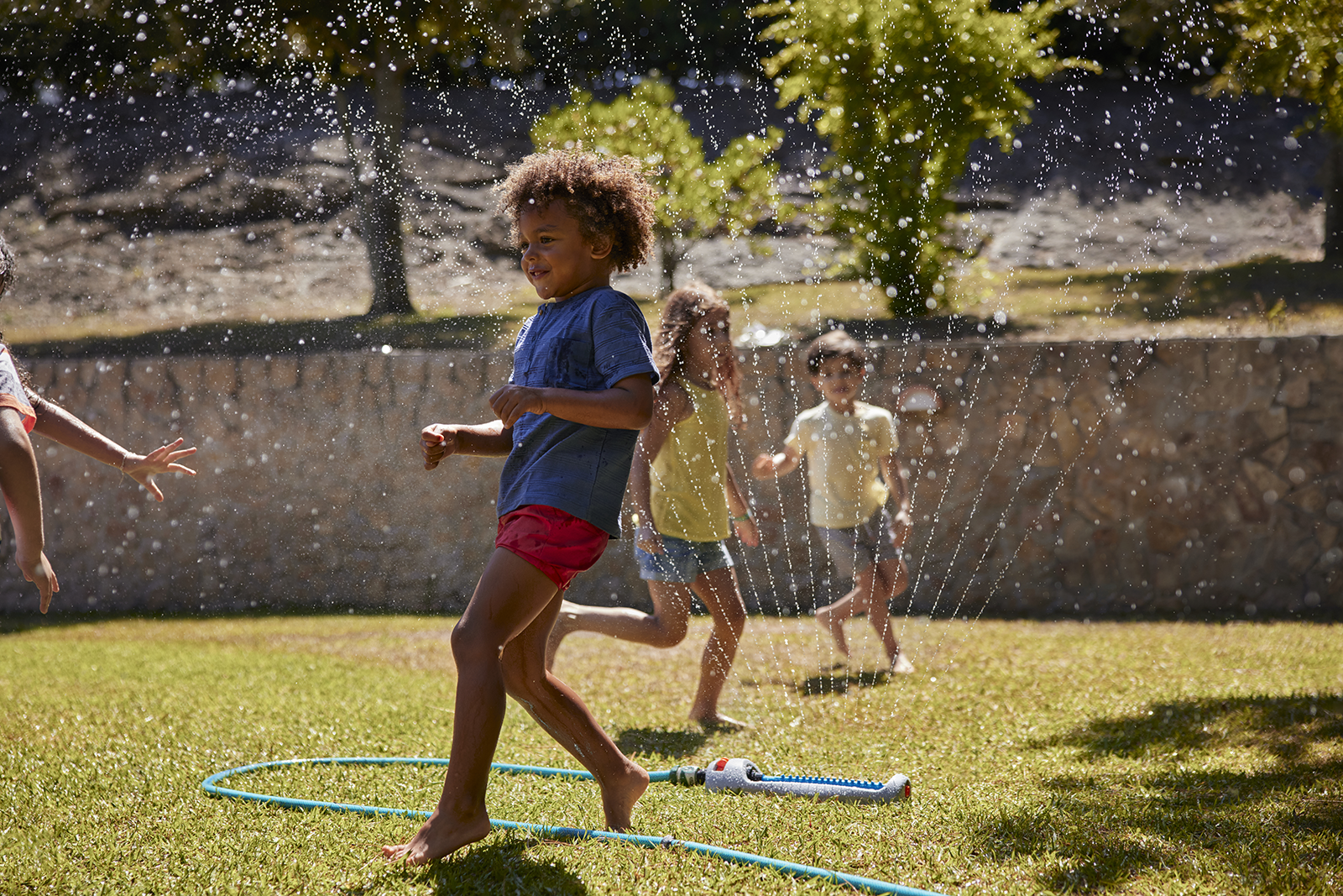 Crianças brincando com água em um jardim