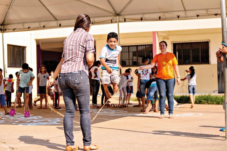 Crianças do ensino fundamental em uma sala de aula jogando futebol de mesa.  diversão durante o recreio na escola.