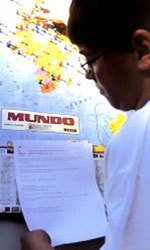 Aluno lê uma mensagem diante do mapa-múndi: alfinetes coloridos para marcar localizações que rendem atividades bastante curiosas Foto: Massao Gotto Filho