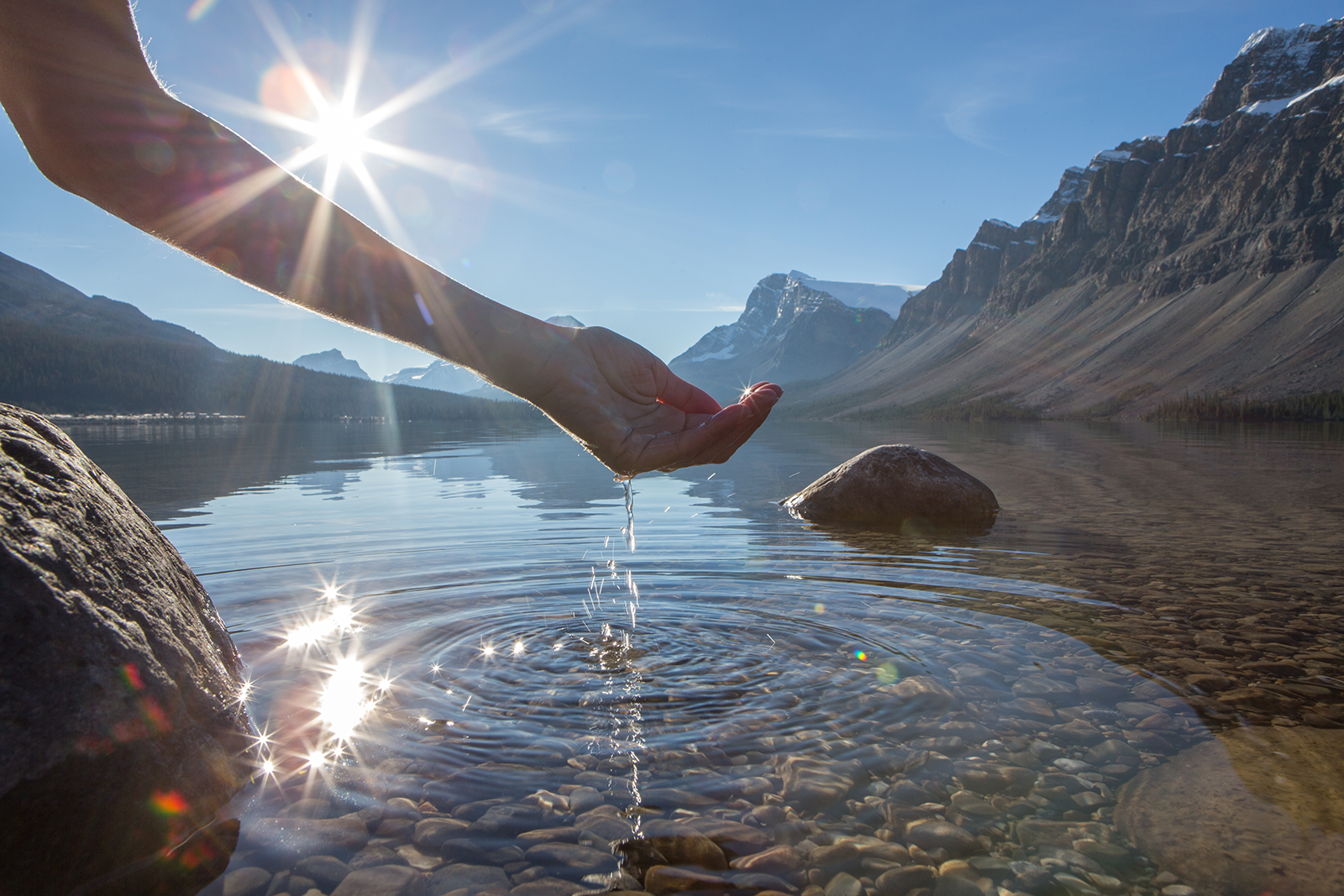Mão humana em forma de concha para pegar a água fresca do lago