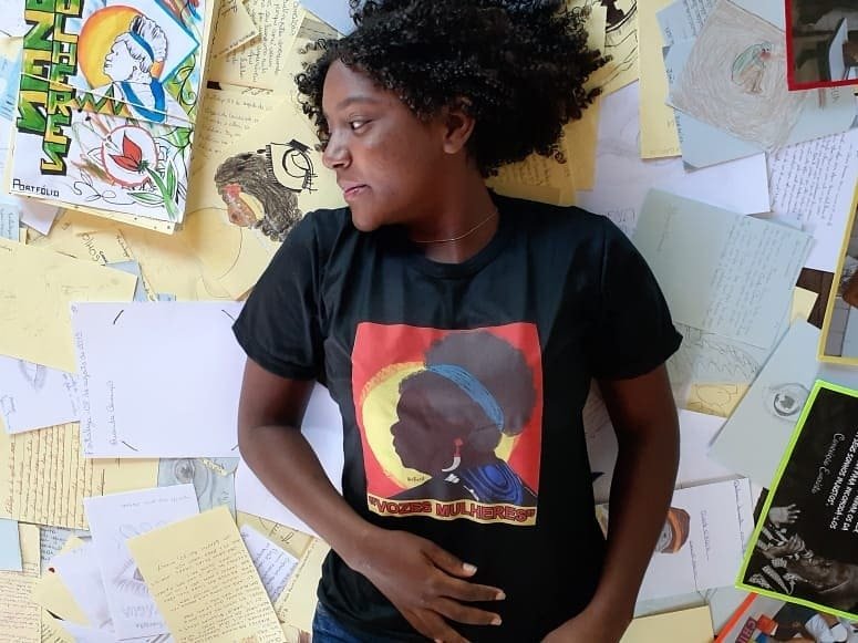 Uma das alunas da professora Camile Baccin de Moura deitada em meio aos trabalhos inspirados pelas obras lidas no projeto