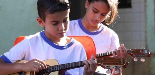Experimentação de instrumentos musicais Nas duas aulas semanais que Alessandro tinha com cada uma das turmas da escola, ele propôs aos alunos que experimentassem diferentes instrumentos. Passadas algumas aulas, cada aluno escolheu seu instrumento de estudo. O Rafael, na foto, escolheu o cavaquinho e aprendeu a ler a música no sistema de tablatura. Foto: Marco Monteiro