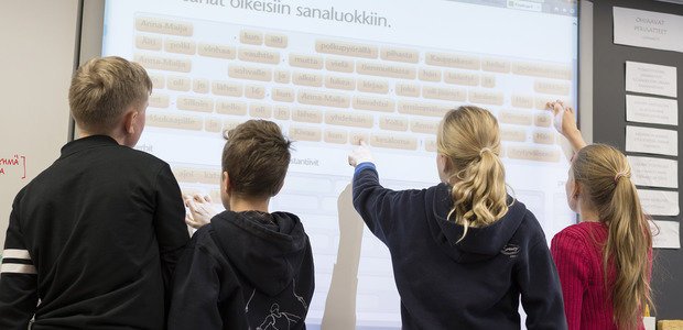 Crianças brincam com jogo educativo eletrônico